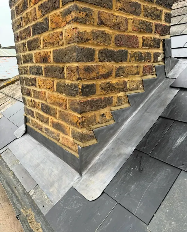 New lead flashing around a brick chimney on a slate roof